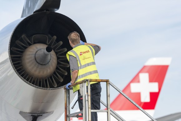 Technician checking engine of a plane at the airport of Zurich