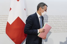 Ignazio Cassis next to Swiss flag