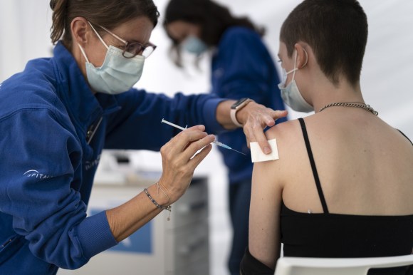 Una enfermera vacuna a una joven