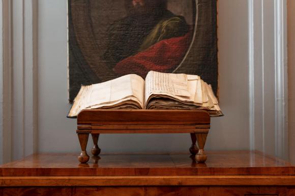 كتاب قديم نادر معروض فوق مصطبة خشبية