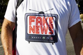 Person wearing t-shirt with Fake News logo