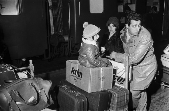 Familia con maletas en andén de trenes