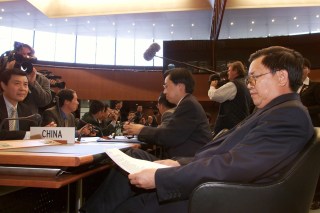 2001年9月17日、ジュネーブで開催された中国のWTO加盟に関する最後の協議に関するWTO開会式の前に、プログラムを読む中国の交渉団代表の龍永図（ロン・ヨントゥ）氏