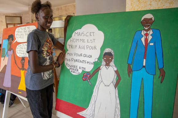 Jeune fille posant à côté du tableau qu elle a peint dénonçant les mariages forcés