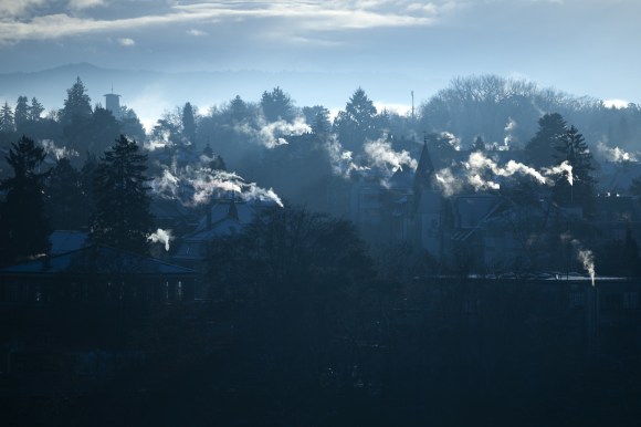 Fumes arise from chimneys over an idyllic Swiss town