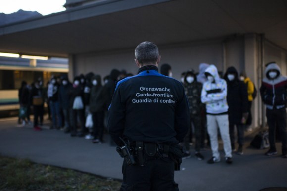 أفراد من حرس الحدود ومجموعة من اللاجئين الأفغان على الحدود السويسرية بالقرب من سانت غالن