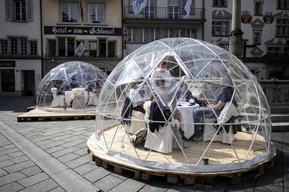 Diners eat in the street in Switzerland enclosed in a plastic bubble
