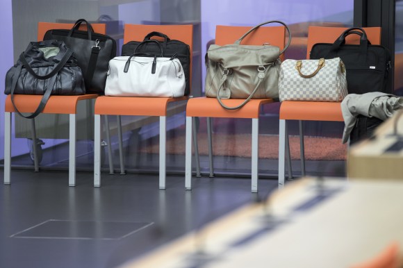 Handbags on row of chairs
