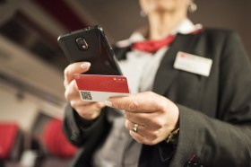 A conductor checks a Swisspass card on a train