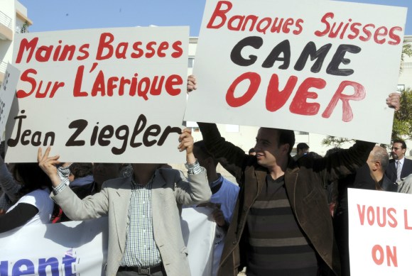 متظاهرون يرفعون لافتات أمام سفارة سويسرا في تونس العاصمة