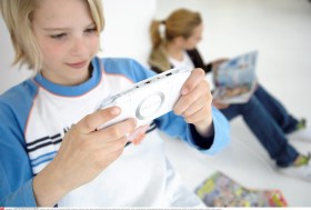 طفل يتابع لعبة فيديو على شاشة هاتف جوال