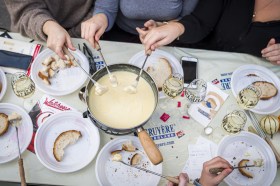 Three people enjoying a cheese fondue meal