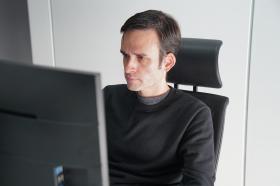 رجل يعمل أمام شاشة حاسوب