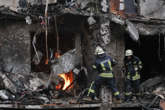 Firefighters tackle a blaze in a bombed building in Kyiv