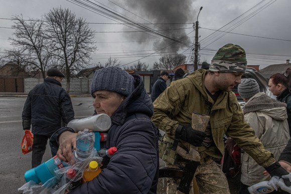 Man holding possessions is among people fleeing Kyiv.