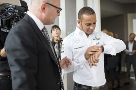 Lewis Hamilton looks at a watch
