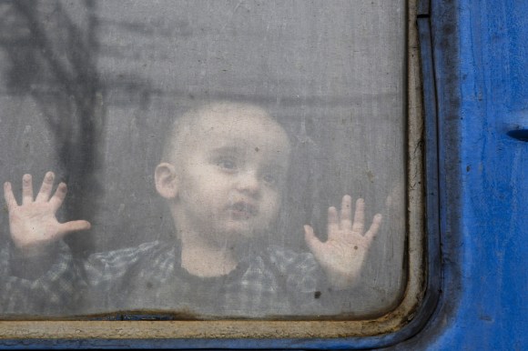 طفل صغير ينظر إلى الخارج من وراء نافذة قطار مغادر