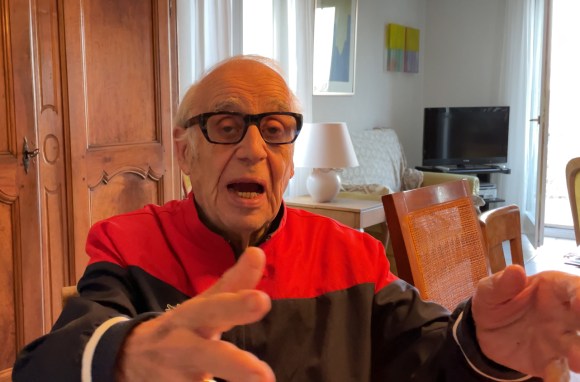 Um homem de óculos e gesticulando com as mãos