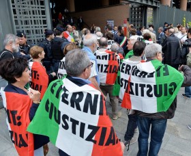 Protestantes com bandeiras italianas fora do edifício do tribunal