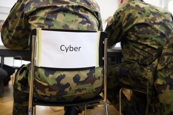 Men in military fatigue jackets, chair with label Cyber