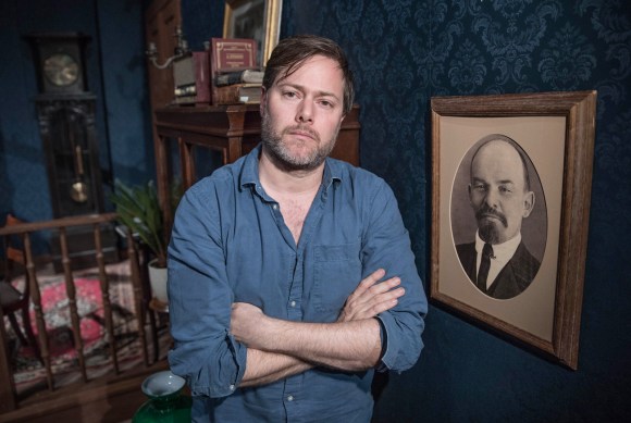 Milo Rau neben einem Bild von Lenin