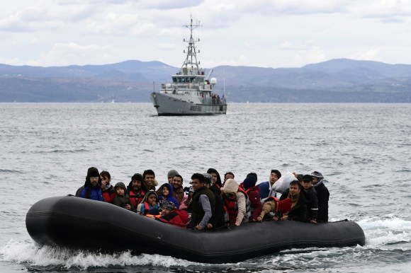 Dinghy with refugees with Frontex vessel behind