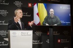 Ignazio Cassis am Rednerpult und ukrainischer Premierminister auf einem Bildschirm