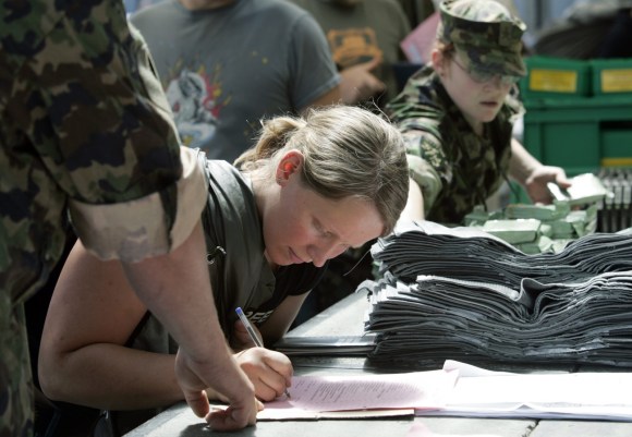 Swiss army female recruit signing a form