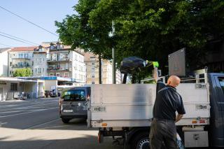 Mann wirf Müllsack auf Lastwagen