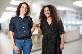 Dois pesquisadores posando para fotógrafo em frente a um laboratório