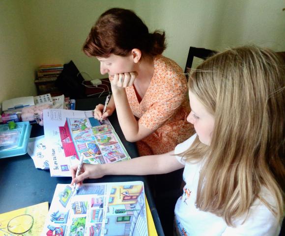 Dos chicas en una mesa con libros de ilustraciones