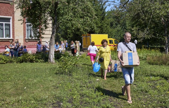 رجال ونساء يتلقون مساعدات إنسانية في ضواحي خاركيف بأوكرانيا