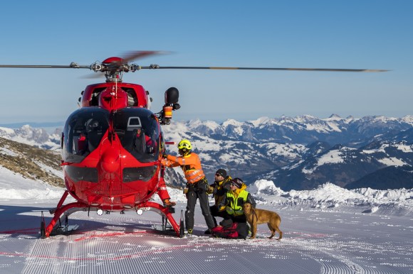 فريق انقاذ وطائرة مروحية في منطقة جبلية تكسوها الثلوج