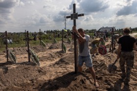 People erecting crosses ina cemetery in Ukraine