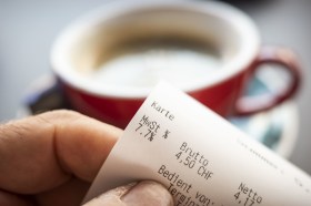 Pessoa lê conta de café