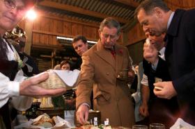 Prinz Charles und Adolf Ogi bedienen sich an einem Buffet mit Zopf und Käse und Wurst.