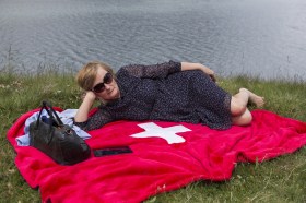 A Russian tourist on a towel with a Swiss cross in lake Daubensee (2017).