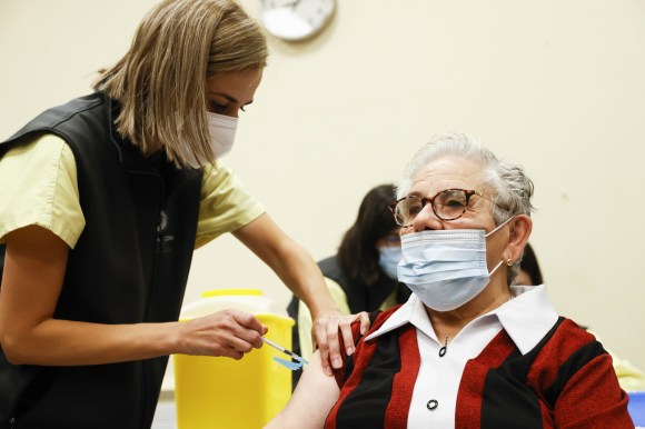 Enfermeira aplicando injeção em idoso