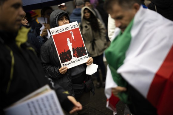 متظاهرة في زيورخ تحمل لافتة كُتب عليها السلام لإيران، والسلام للعالم.