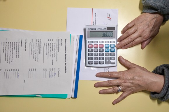 Elderly person calculates their disposable income in Switzerland