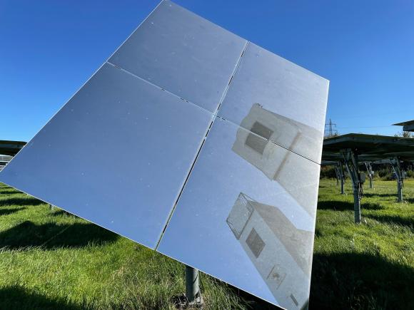 The two towers of Synhelion s test plant reflected in one of the mirrors on the field