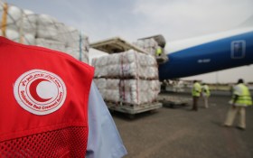 ICRC worker wears clothing bearing red crescent symbol.