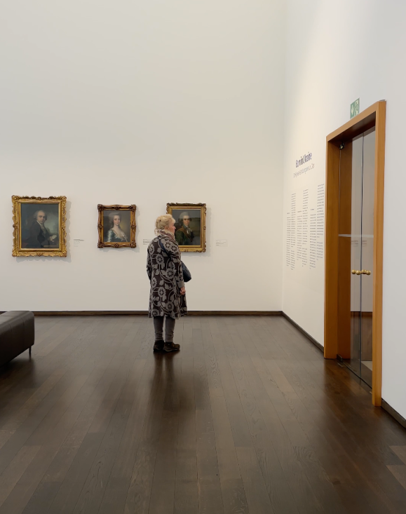 A woman reading a text on the wall of a museum