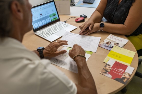 due persone sedute attorno a una scrivania