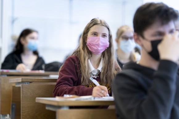 Schoolgirl in class with mask