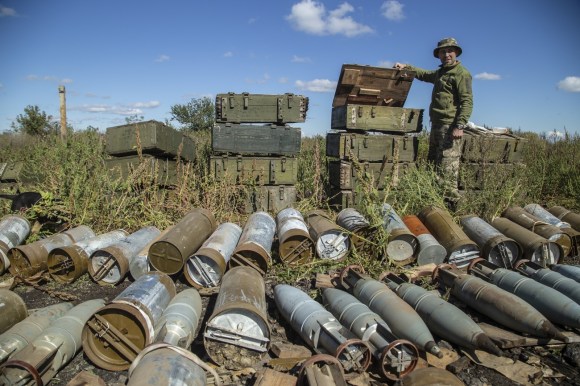 A Ukrainian soldier inspects ammunition left by the Russian troops