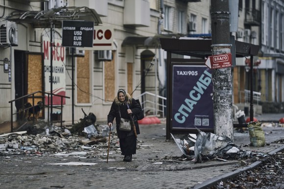 Elderly woman walking bombed out street of Donetsk, Ukraine.