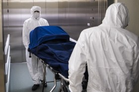 Health workers transport a deceased person