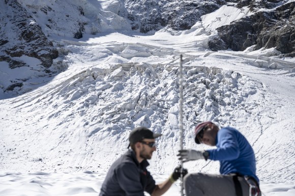 氷河の積雪量を調べるGLAMOSの職員