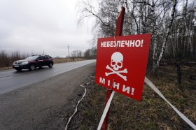 Une voiture passe devant un panneau d'avertissement de mine en Ukraine